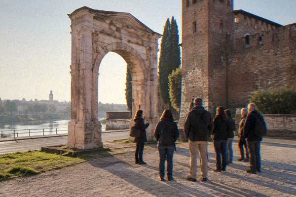 Guide talking to a small walking group on a Verona street