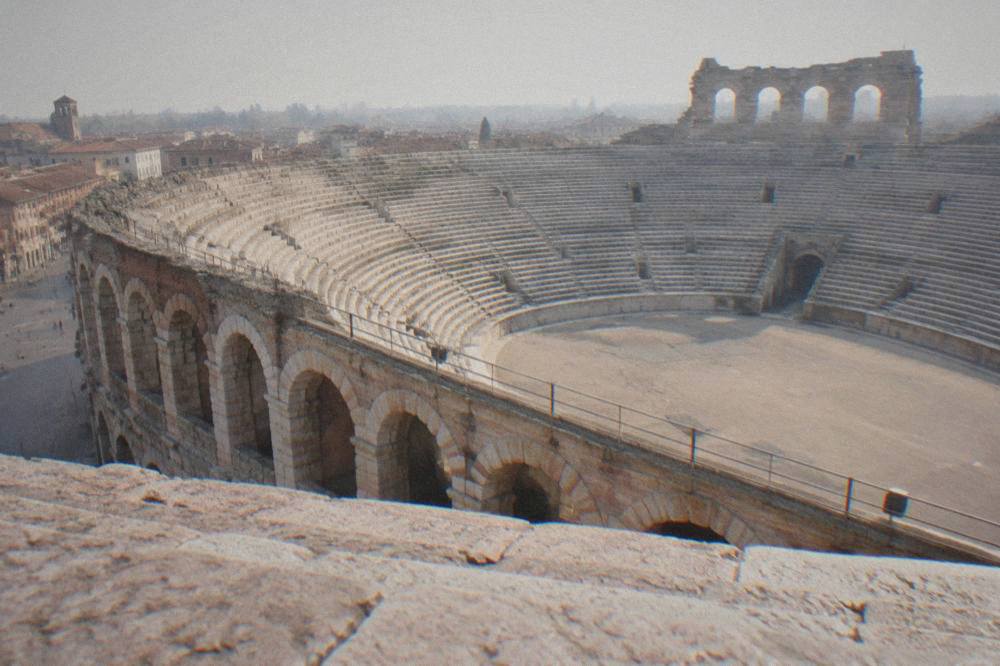The empty stone steps and central floor of the Verona Arena seen from the upper gallery