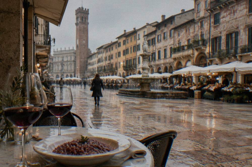 Glasses of red wine and a plate of rice cooked in wine on a restaurant table