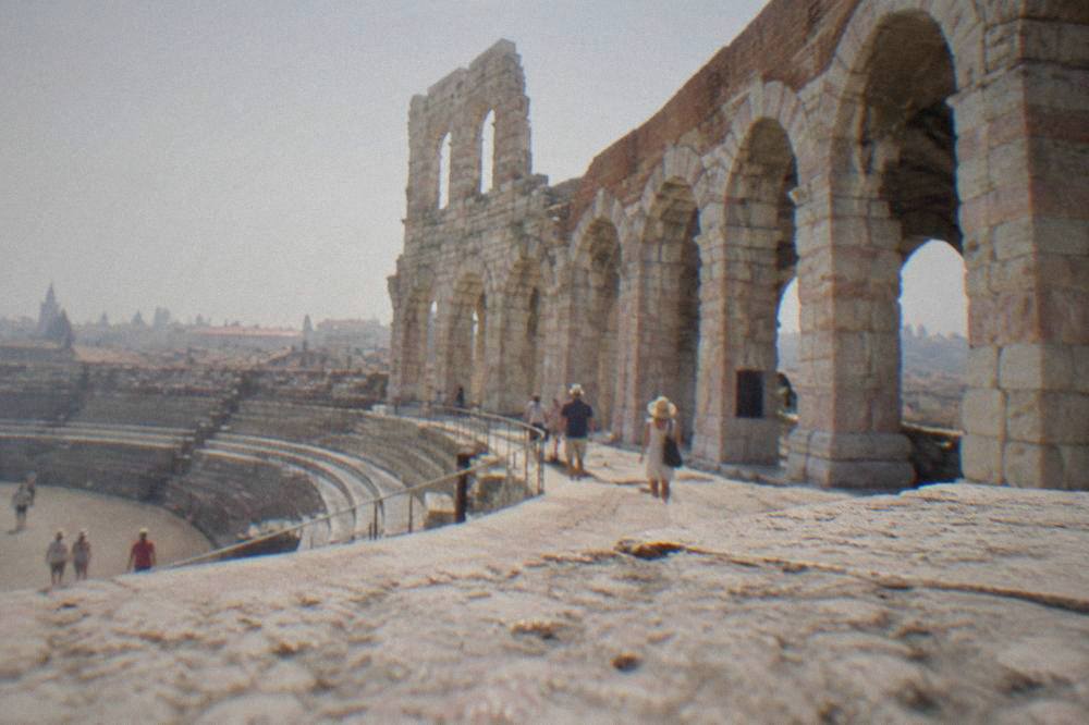 The open stone arches of the Arena di Verona's surviving wing seen from inside the amphitheatre