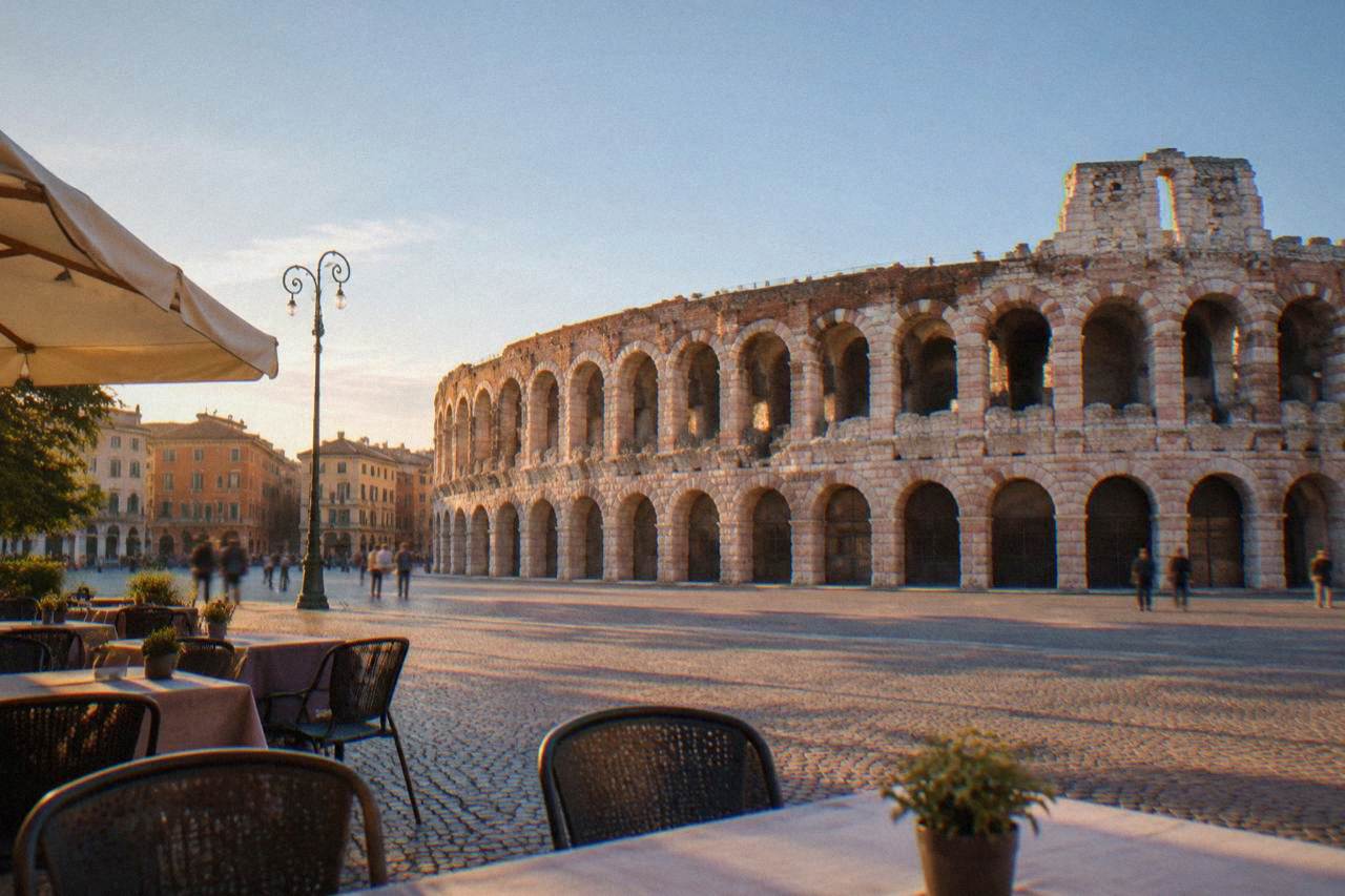 The Roman Arena of Verona seen from Piazza Bra at golden hour with cafe tables in the foreground