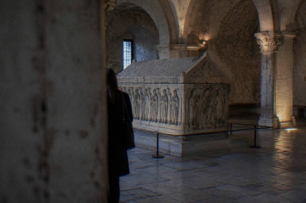 A medieval stone sarcophagus displayed inside a vaulted hall in Verona