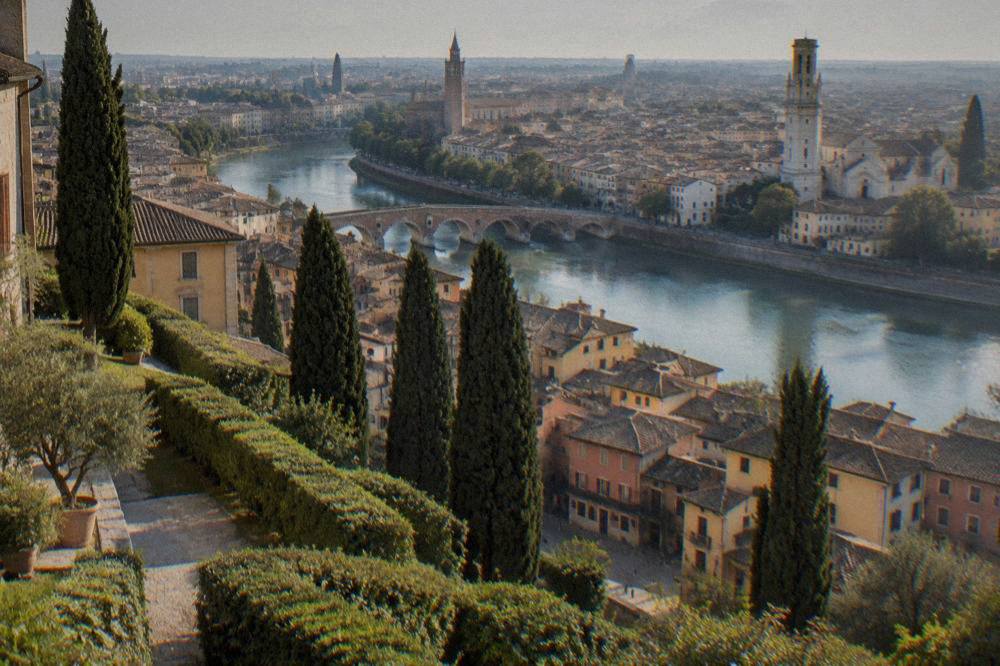 Terraced garden hedges and cypress trees overlooking Verona rooftops