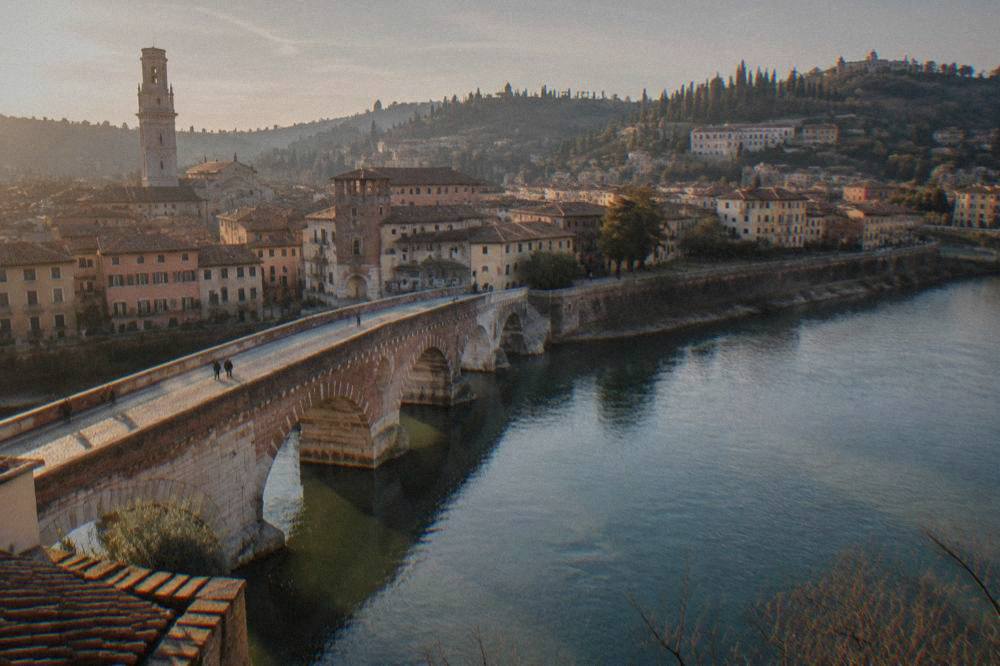 Evening light on the Adige river with Ponte Pietra and the Verona hills behind it