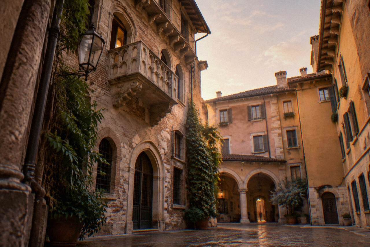 A stone balcony above a quiet medieval courtyard in Verona at golden hour