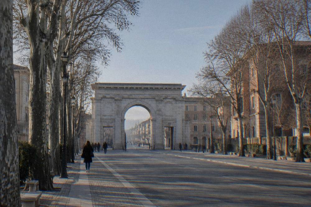 A wide tree-lined avenue in Verona leading from the Porta Nuova gate toward the historic centre