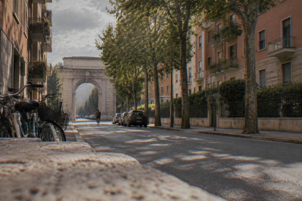 A quiet residential street in the Porta Nuova district of Verona with apartment buildings and parked bicycles