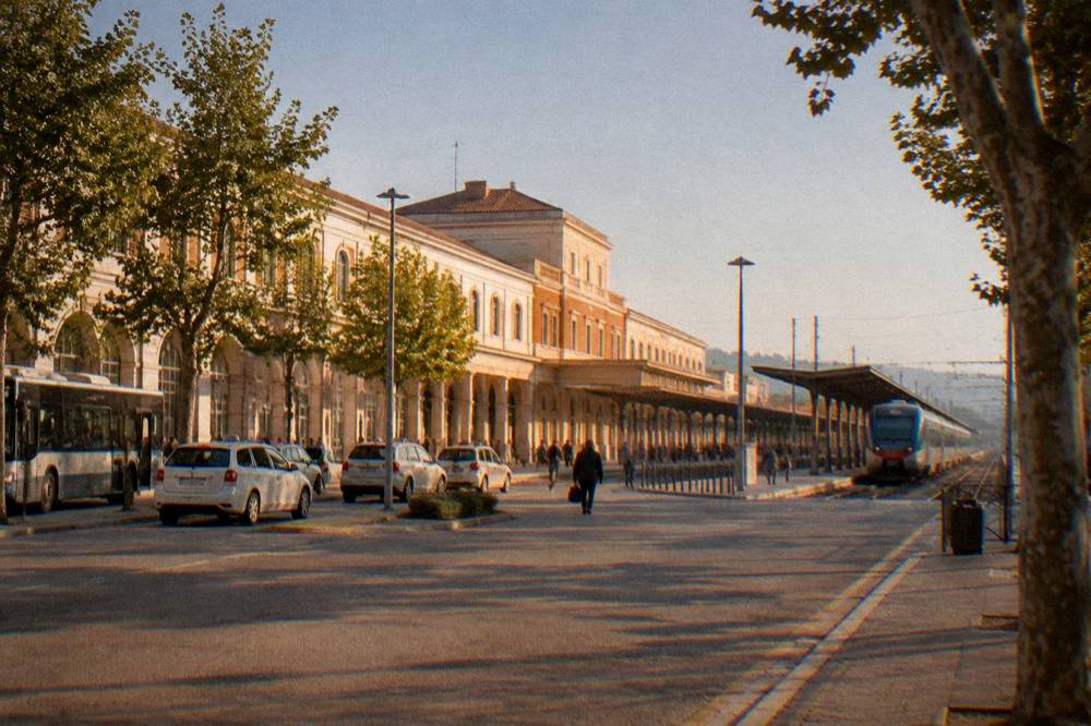 A regional train pulling into the platforms of Verona Porta Nuova station under a clear sky