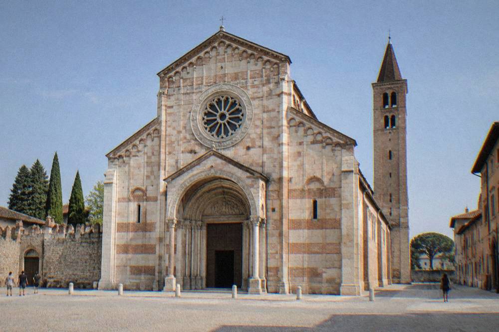 The Romanesque facade and rose window of the Basilica di San Zeno in Verona seen from its forecourt
