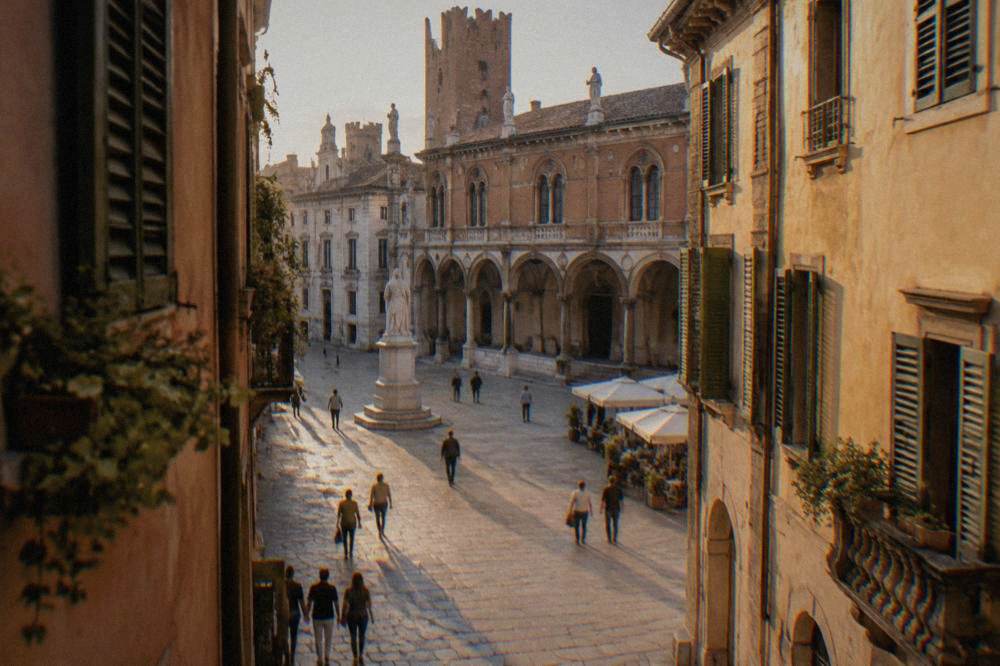 Medieval square with statues and arcades in Verona seen from a narrow lane opening
