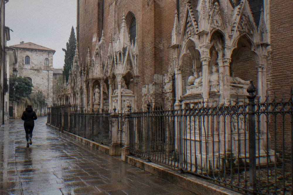 Iron railing enclosing carved Gothic tombs against the wall of a small brick church