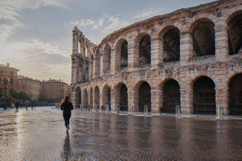 The surviving Ala wing of the Arena with its arches of pale stone against the sky