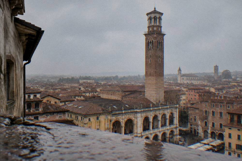 Comparison scene of the Verona skyline with the Torre dei Lamberti rising over the rooftops
