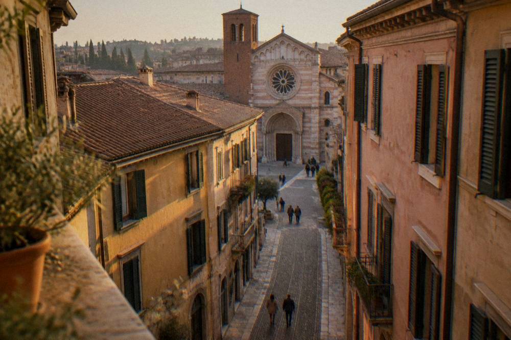 A narrow cobbled street in the cathedral quarter of Verona leading towards the church facade