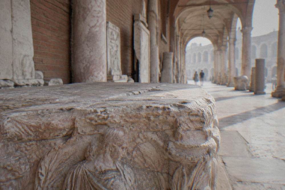 Close view of a weathered Roman funerary tablet with lines of Latin capital letters