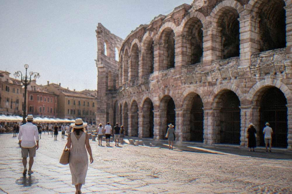 Wide stone-paved square with the amphitheatre wall on one side