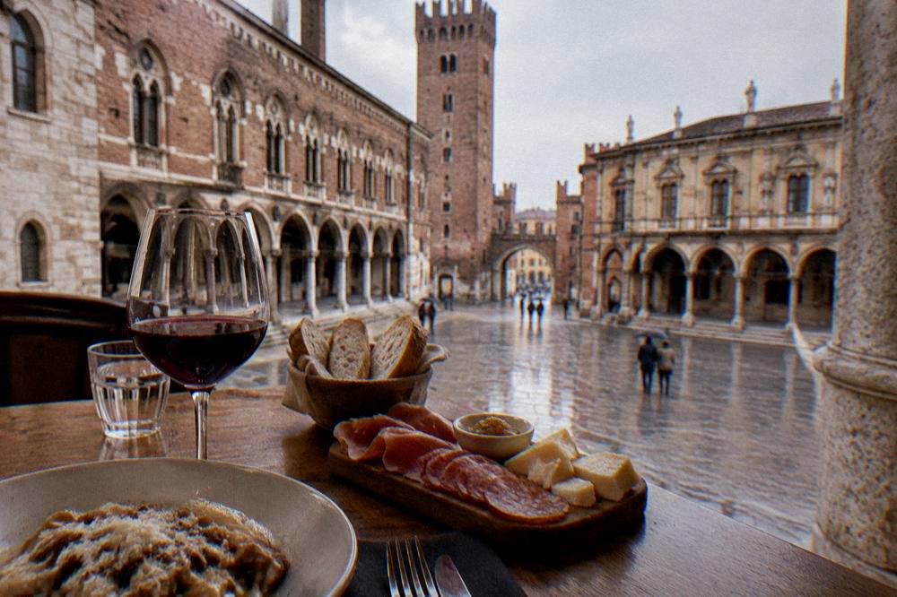 Traditional Veronese dishes and a glass of red wine on a wooden table in a small restaurant