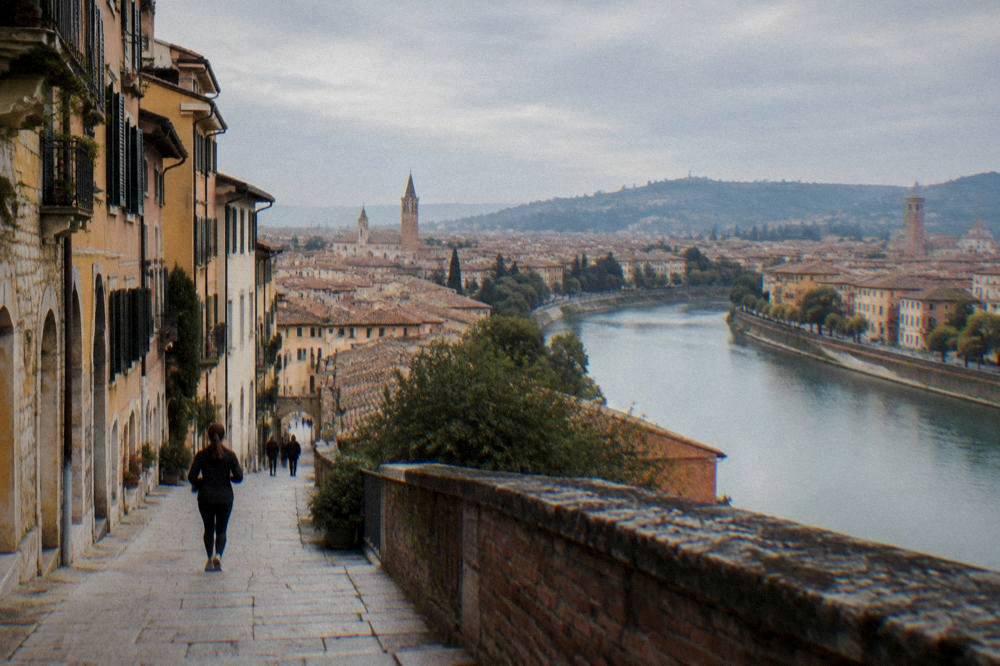 View over Verona rooftops and the Adige river toward hills on the horizon