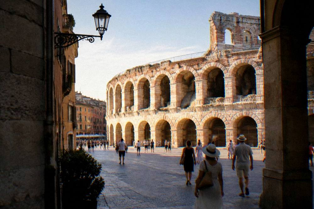 Roman amphitheatre facade seen through a city street in Verona at golden hour