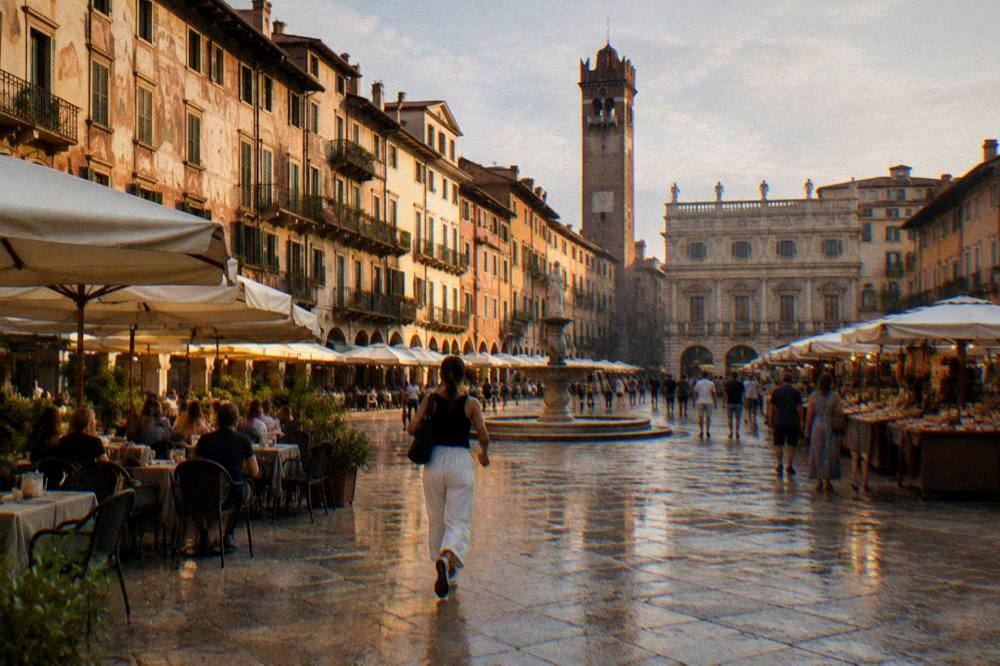 People sitting at outdoor tables in a historic Italian square in warm evening light