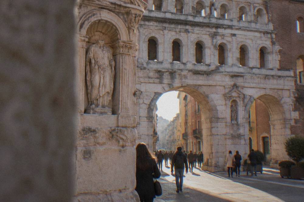 Close view of carved stone niches and an inscription panel on the front face of a Roman gate
