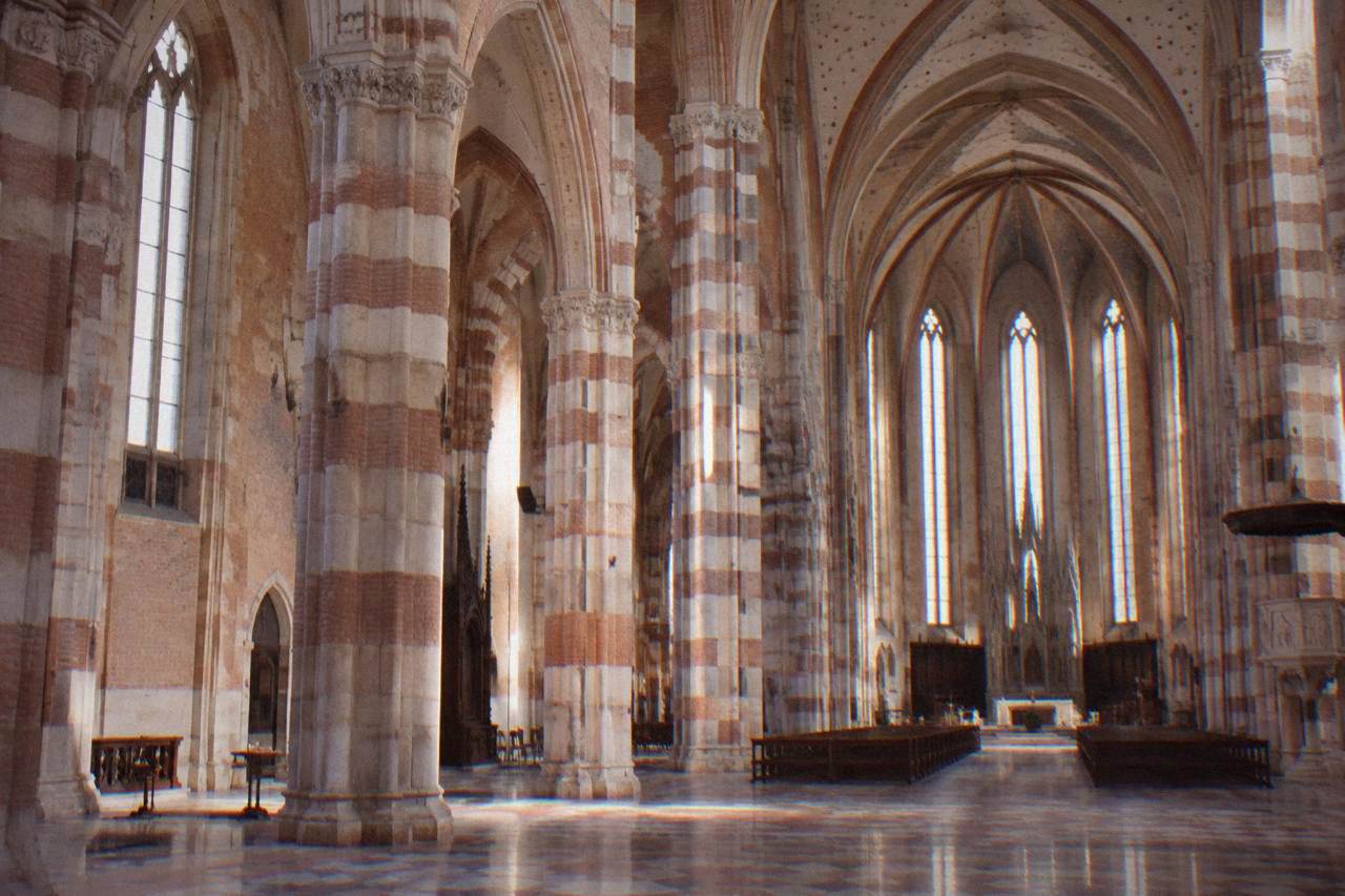 Gothic church interior with tall striped columns and vaulted ceiling