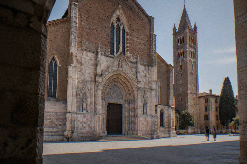 Marble church facade seen from a small square in daylight