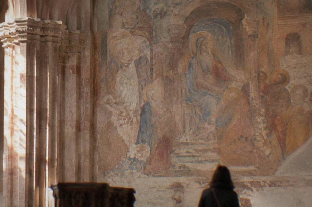 Frescoed wall inside a church with faded Renaissance painting