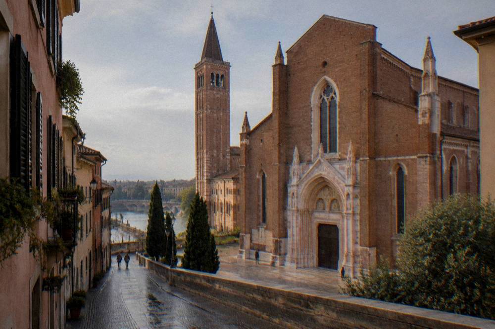 Narrow cobblestone street leading toward a church tower
