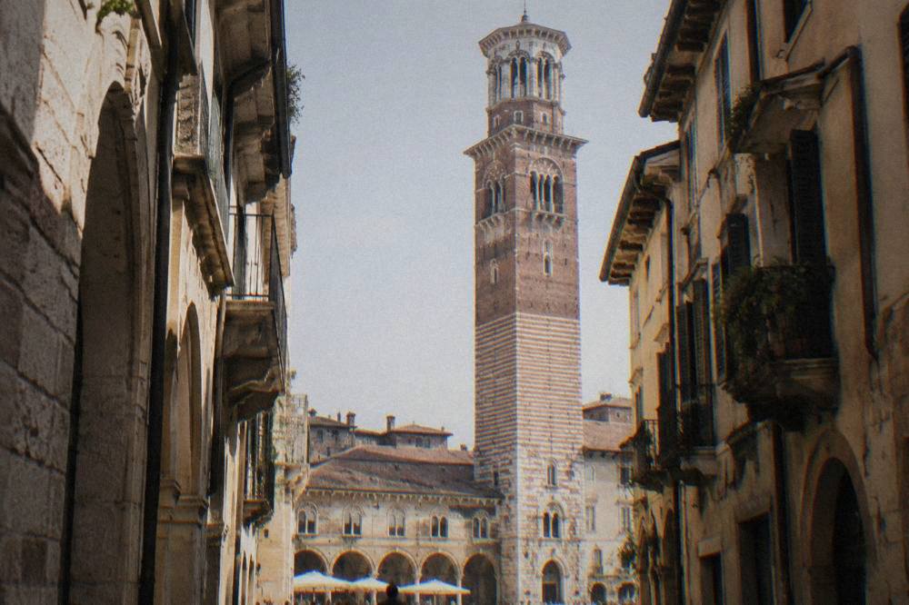 The lower stone stages of the Torre dei Lamberti seen from a narrow lane in central Verona