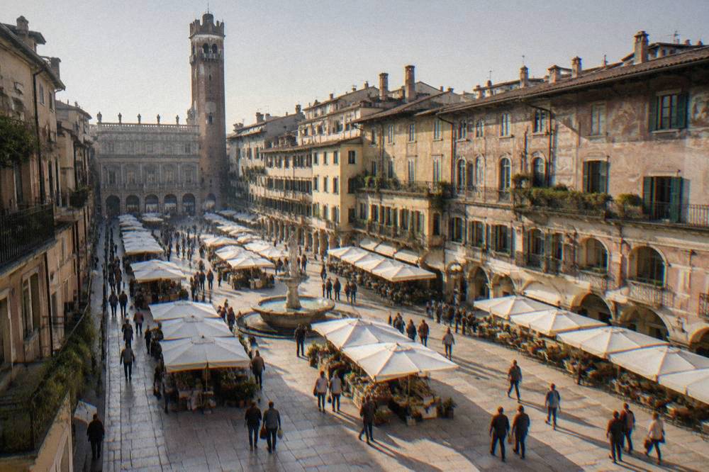 Tourists gathering on Piazza delle Erbe in Verona with the Torre dei Lamberti rising above the market square