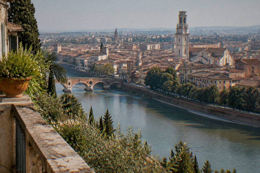 Verona seen from a hillside terrace across the river with the civic tower rising above the rooftops