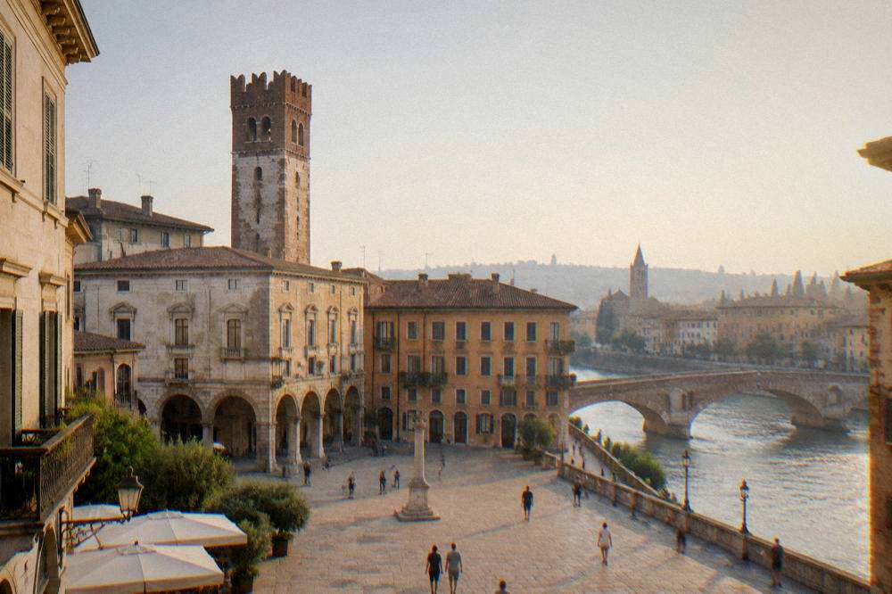 A stone tower and historic facades around a sunlit square in Verona at golden hour
