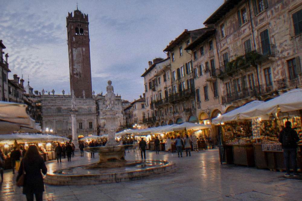 Tall brick and stone tower rising above a historic market square