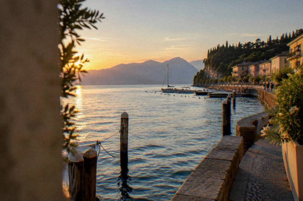 View across Lake Garda water towards mountains from a Bardolino pier at dusk