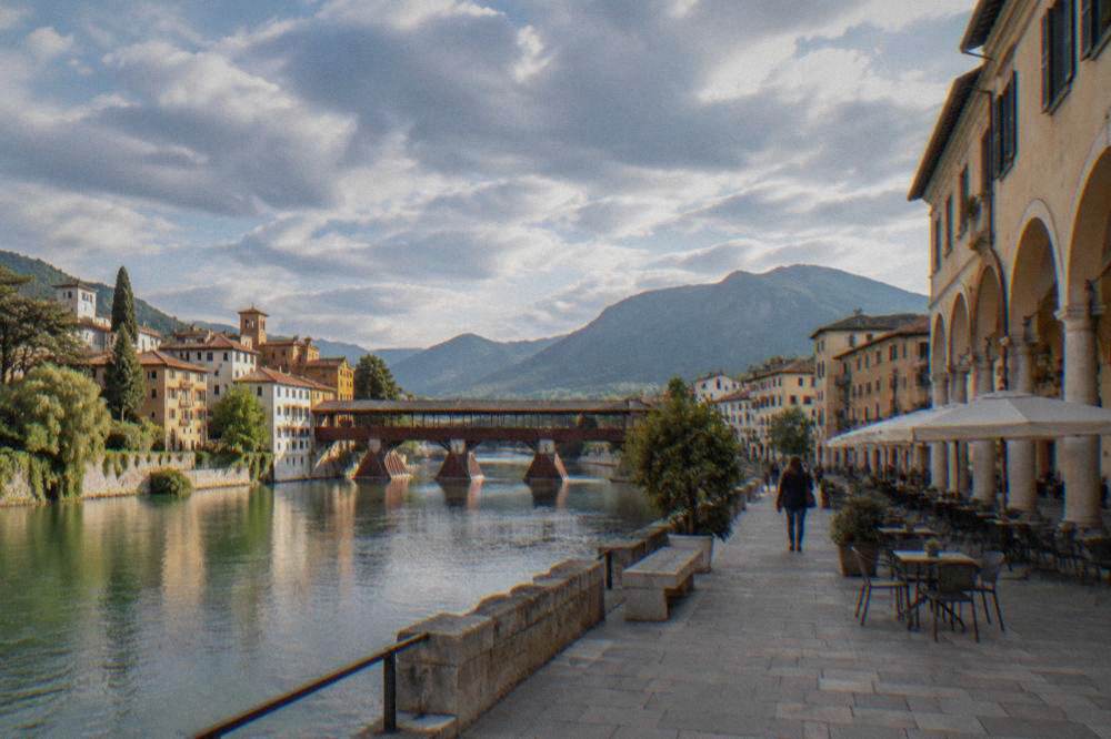 An arcaded Italian town square with cafe tables and painted facades