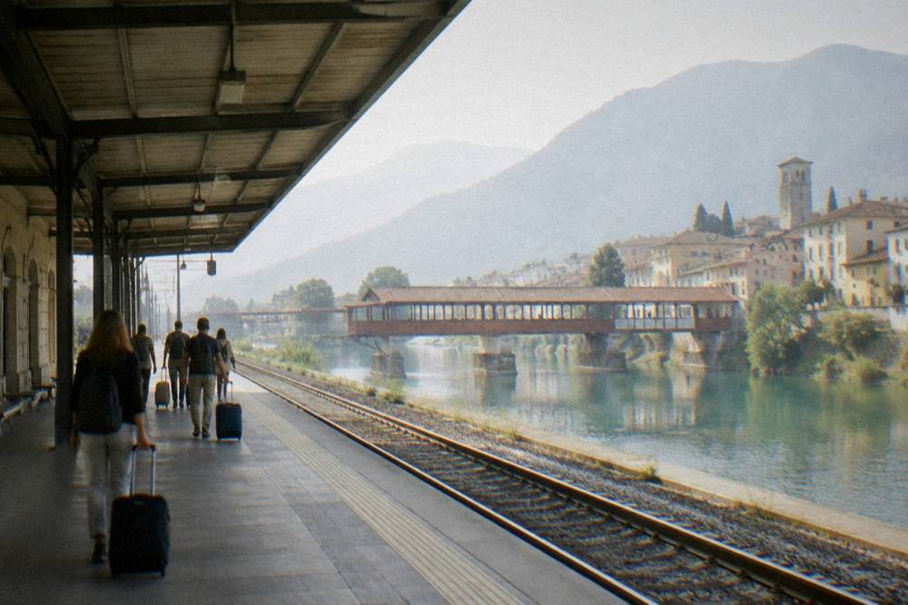 A station concourse in the early morning with travellers walking toward the platforms