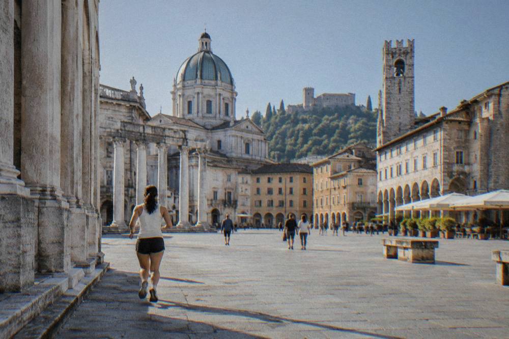 An Italian provincial city square with arcaded buildings and a stone tower under a clear sky