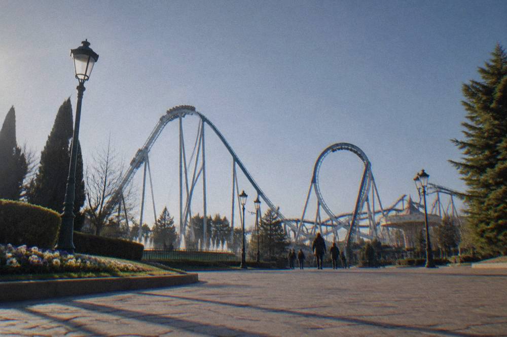 Roller coaster track looping against a blue sky at a large theme park