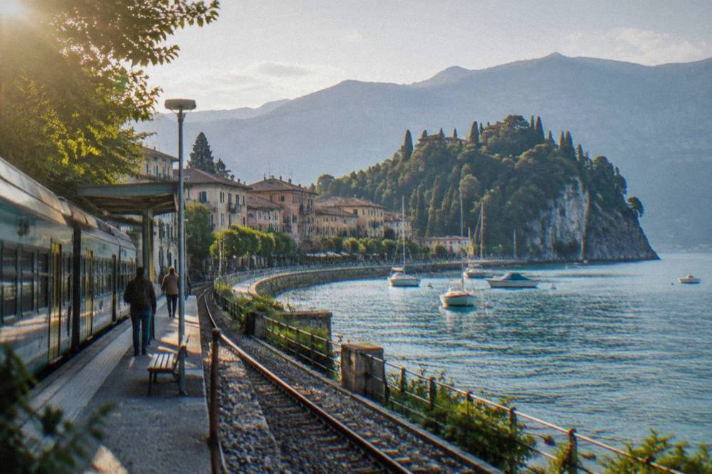 A regional train waiting at a small Italian station near the Lake Garda shore
