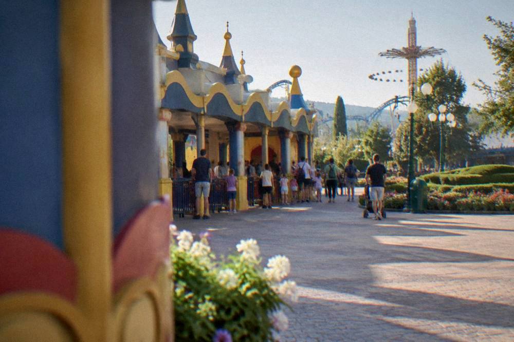 Children and parents queuing at a colourful theme park entrance gate