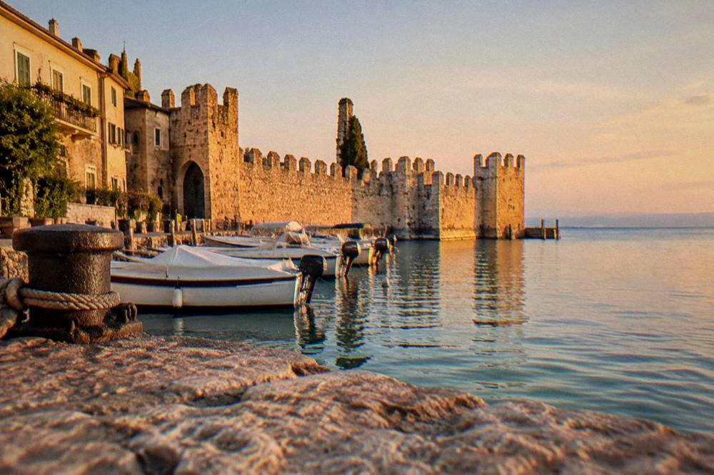 Sunset light on the harbour walls of Lazise with Lake Garda beyond
