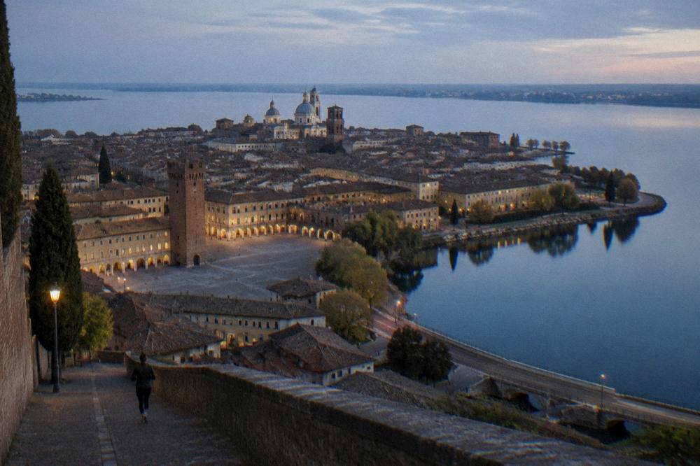 An aerial view of a walled city encircled by wide still lakes