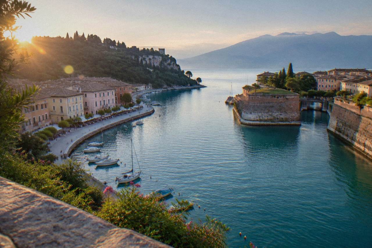 Walled fortress town of Peschiera del Garda where the Mincio river leaves Lake Garda, with pastel buildings along the water