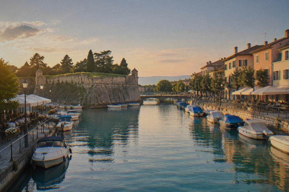 Canal in the centre of Peschiera del Garda with bridges and restaurant tables along the water