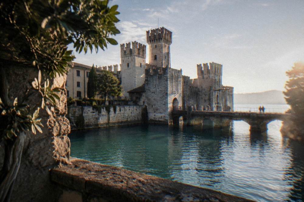 Narrow peninsula with a castle on the water and a stone causeway