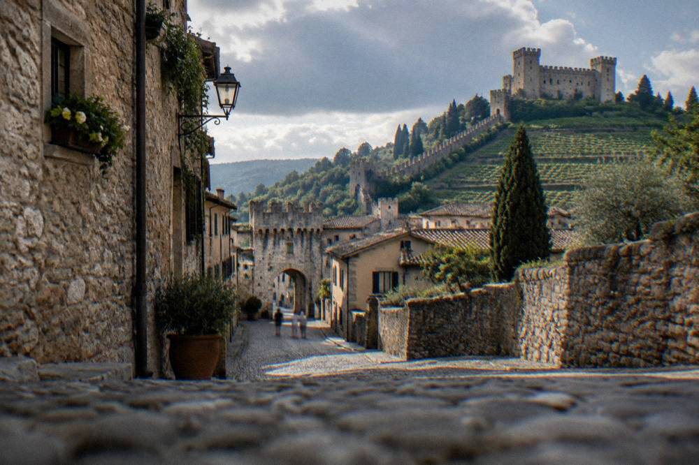 A cobbled street inside a small walled medieval town with stone buildings
