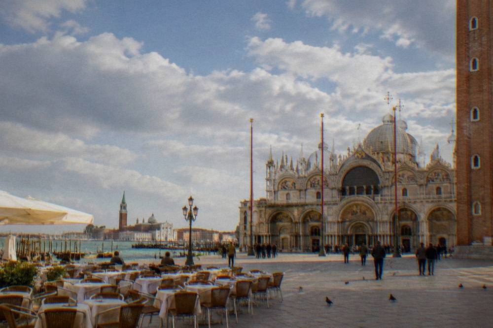 St Mark's Square in Venice with the basilica facade and café tables