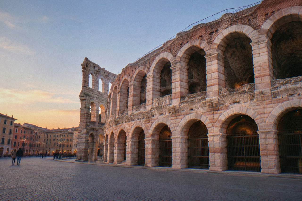 The pink stone tiers of the Verona Arena rising above Piazza Bra at golden hour
