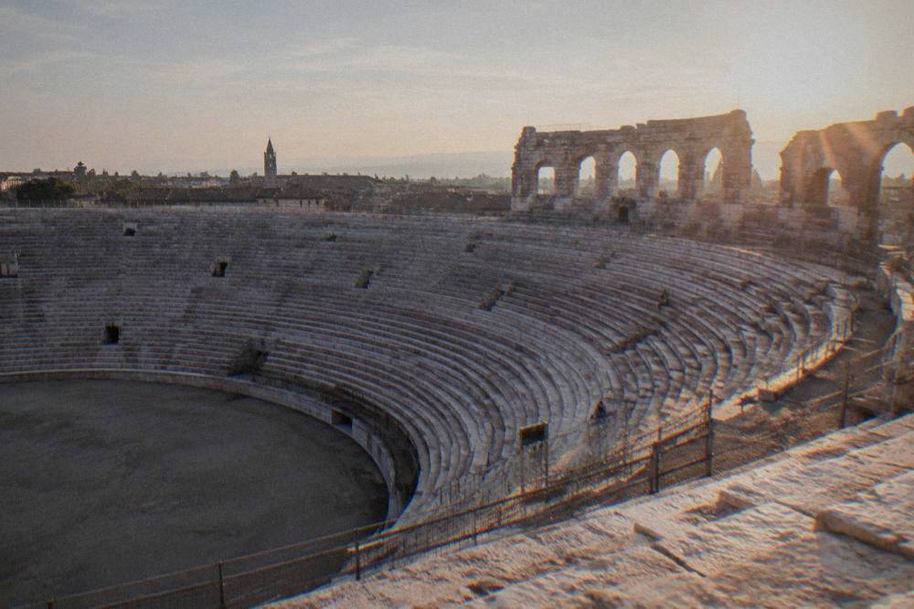 Curved rows of pale stone steps inside the Verona Arena seen from the upper tier